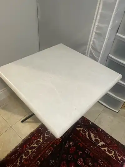 This folding table features a durable white top and a sturdy black metal frame, making it perfect fo...