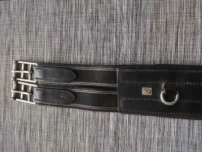 For sale: Horze brand 50" black leather anatomical girth. Has 3 rings for attachments. In good used...