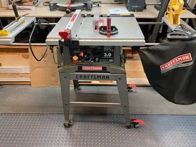 Scie a table de 10 po.sur support roulant. Moteur de 3 H.P., 15A, avec entrainement direct a rouleme...