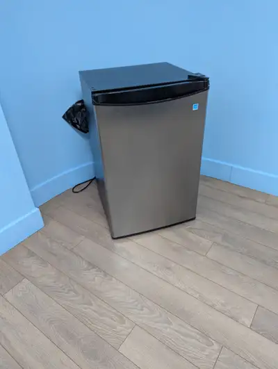 Mini-frigidaire compact avec fini acier inoxydable. Petit compartiment de congélation. Idéal pour bu...