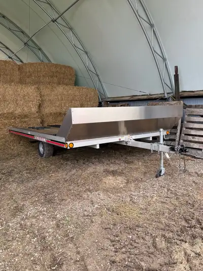 This Triton Elete 12’ is an aluminum framed flatbed trailer with a wood deck and front stone guard....
