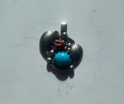 This striking SW Native American silver pendant features beautiful turquoise and coral stones, showc...