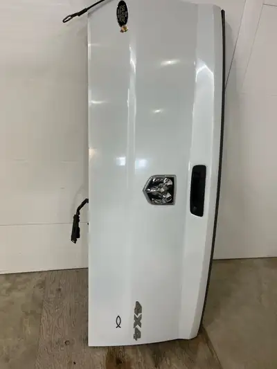 I'm selling a used Dodge Ram tailgate in white, complete with the RAM logo and in good condition. Th...