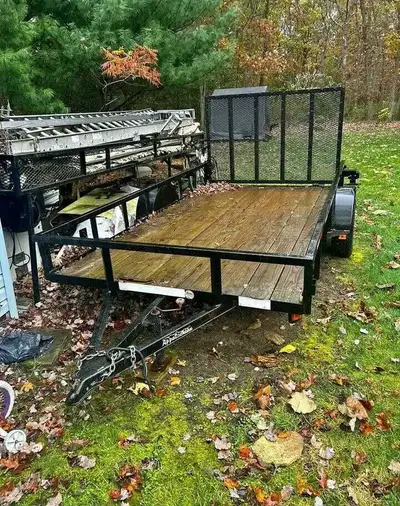 This is a robust utility trailer, perfect for hauling equipment or materials. It's showing its age b...