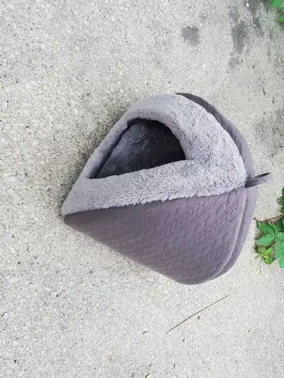 This cozy enclosed pet bed provides a warm and secure sanctuary for your furry friend, featuring a s...