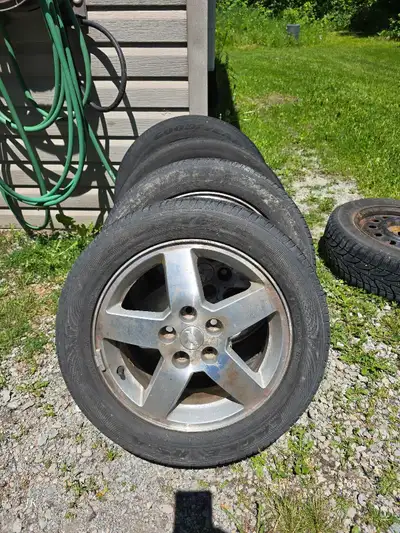 Upgrade your vehicle with this set of four pre-owned Goodyear tires mounted on five-spoke alloy whee...
