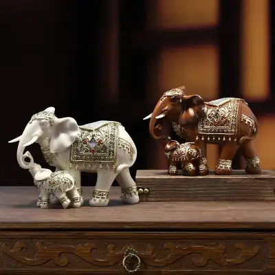 Add a touch of elegance to your home with this charming pair of elephant figurines, featuring a moth...