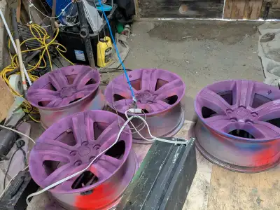 These are a set of four used rims, each featuring a 5-bolt pattern and currently sprayed with a vibr...