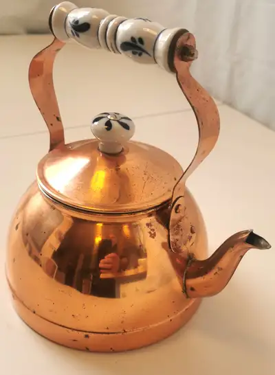 This vintage copper tea kettle with a blue and white Delft porcelain feature design is a charming ad...