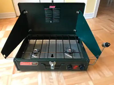 Réchaud de camping Coleman, 2 brûleurs, 16 000 BTU au total. Deux pare-vents, un de chaque côté. Fon...