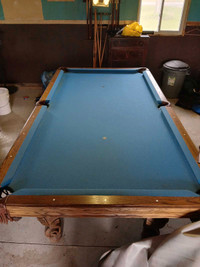 Slate pool table and accessories and large wooden bar. 