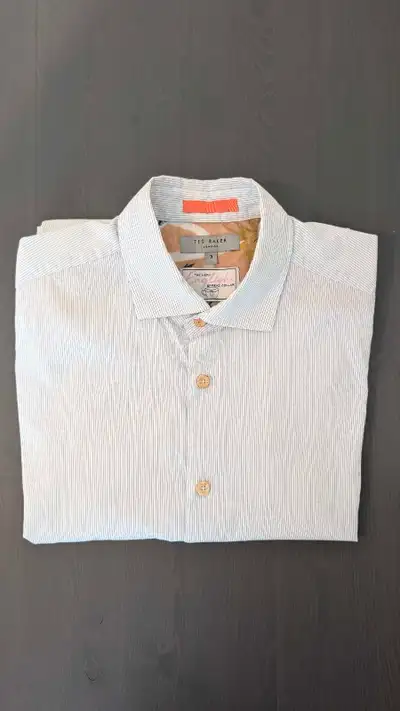 Stylish Ted Baker shirt, size medium. It features a unique pattern with blue stripes on a white back...