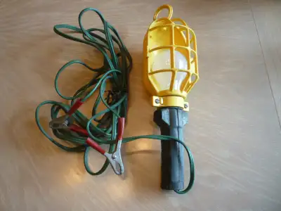 Never used. 15 ft. cord with clips for car battery terminals. New 12 Volt 50 Watt bulb is included.
