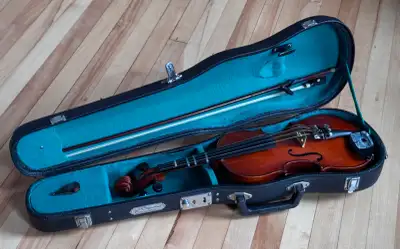 Violon 1/2 de marque Skylark incluant l'étui rigide d'origine et l'archet. Instrument idéal pour l'a...