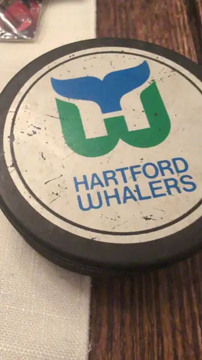 Selling a Hartford Whalers hockey puck, adorned with the Ponderosa Steakhouse logo on the back, a no...