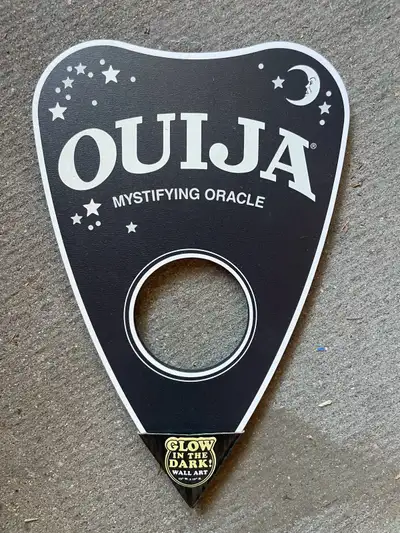Add a spooky touch to your space with this gently used Ouija glow-in-the-dark wall art, measuring 9x...