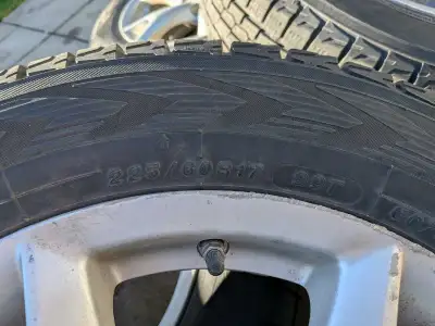 Yokohama 225/60R17 winter tires are mounted on silver Nissan alloy wheels. The tires are the IceGuar...