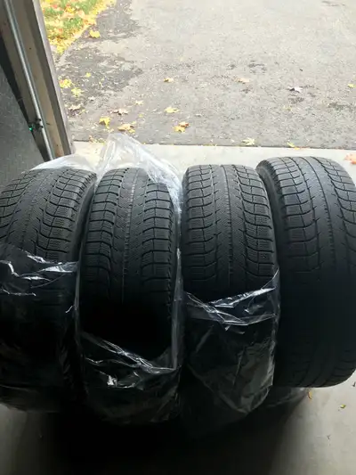 Offering a set of four Michelin winter tires, sized at 255/60R18, ready to tackle the snowy roads. T...