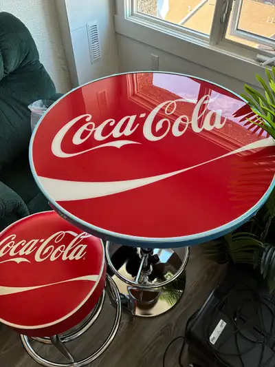 For sale Coca Cola Pub Style Table and 2 padded Coca Cola Bar Stools. Both stools and table have foo...