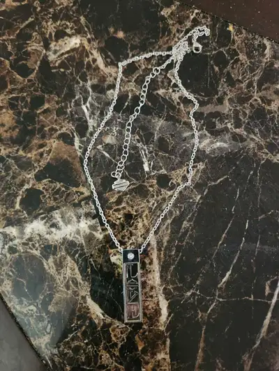 This is a Harley Davidson necklace with a silver chain and pendant. This item is in good condition....
