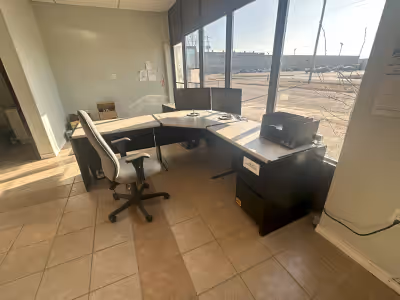 Several matching office desks, black sides and supports, speckled grey tops with black trim, all in...
