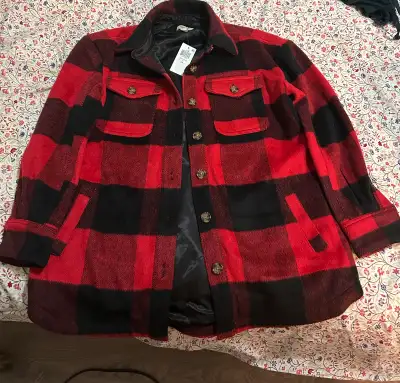 This plaid shacket features a classic red and black check pattern, perfect for adding a touch of coz...