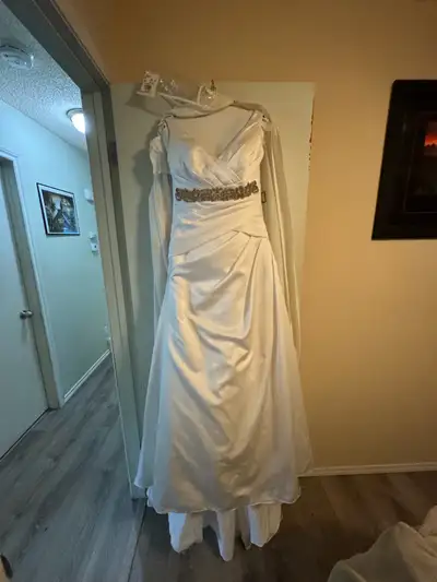 White wedding dress with accent. Has a gentle train and wrist band to hold it up. It’s not from a fa...