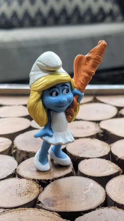Voici une figurine de Schtroumpfette tenant une carotte. Cette figurine est en état usagé - bon, mai...