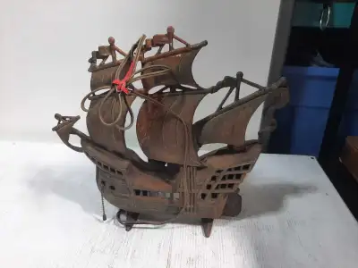 This is a decorative metal ship, perfect for adding a vintage touch to any room. It's in used condit...