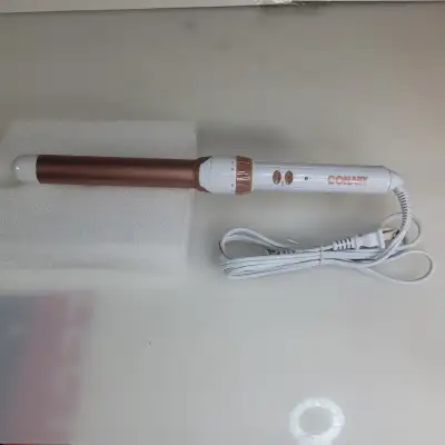 Brand new curling iron in an opened box. Features a rose gold color and white unit that plugs into s...