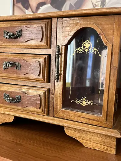 vintage wooden jewelry box with a glass door and drawers., View more