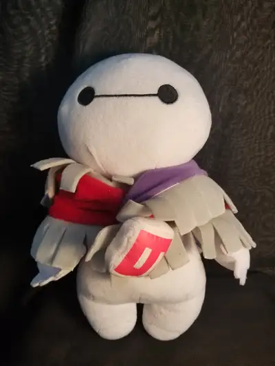 This is a Disney Baymax plush from the movie Big Hero 6, featuring a custom or added red and purple...