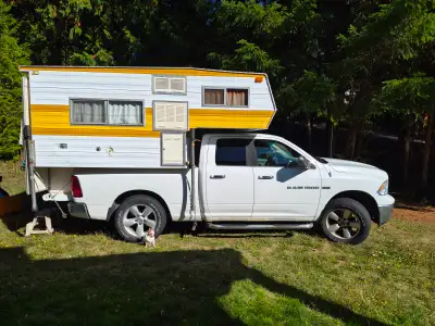 This 2012 Dodge Ram 1500 SLT Quad Cab 4x4 is a reliable workhorse paired with a classic slide-in cam...