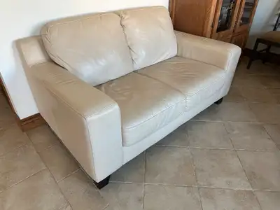 Découvrez ce charmant causeuse en cuir beige, parfait pour ajouter une touche de confort et d'élégan...