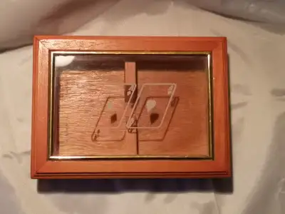 A very nice looking real wood box that holds 2 decks of cards. The lid is on hinges and has a see th...