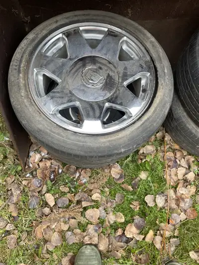 Four Cadillac rims for sale and tires, the tires hold air but are worn but the rims are in good cond...