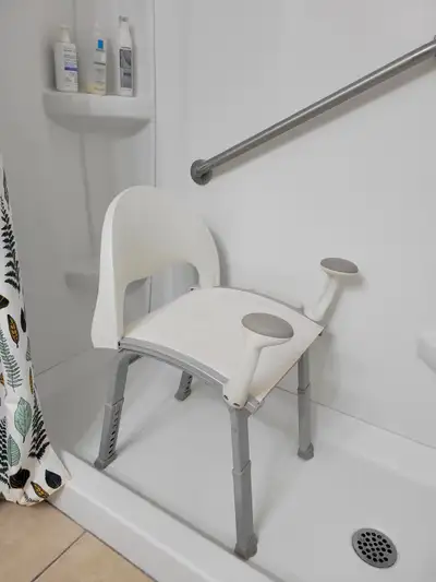 Chaise de douche avec bras et pattes très sécuritaires pour permettre à une personne âgée ou à mobil...