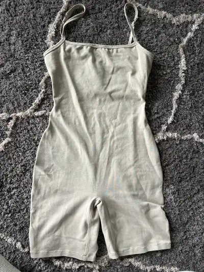 This SKIMS bodysuit is crafted in a neutral tone with adjustable straps for a comfortable and custom...