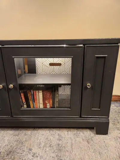 A beautifully refinished modern media console featuring smoked glass display doors, interior LED lig...