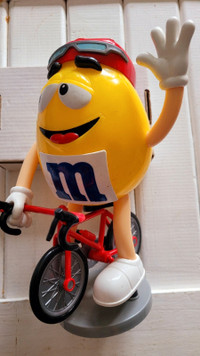 Yellow m and m guy on a bicycle candy dispenser