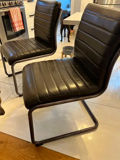 Two brown designer, leather chairs. Very strong, steel legs Extremely comfortable