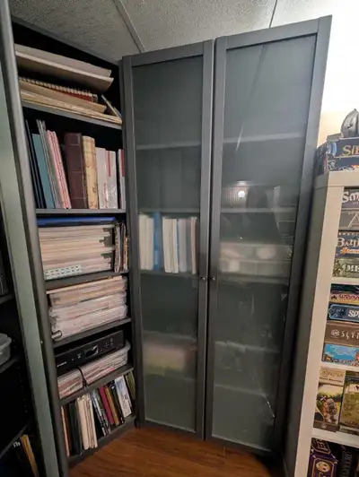 Discontinued color ikea billy bookcase. Dark grey in color. Comes with frosted door. In good shape....