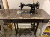 Vintage Singer sewing machine attached to a table with 3 drawers