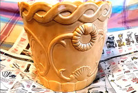 Ceramic planter with sun flower relief design, 9" tall