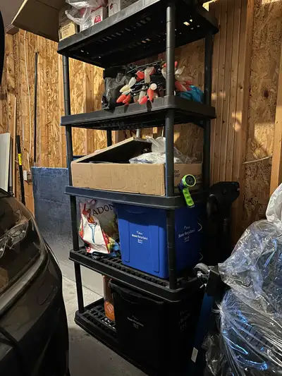 This is a used black plastic shelving unit, perfect for organizing your space. It has 5 tiers and is...