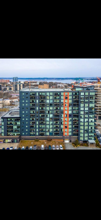Modern top floor condo has open concept living area with floor-to-ceiling windows. Kitchen is equipp...
