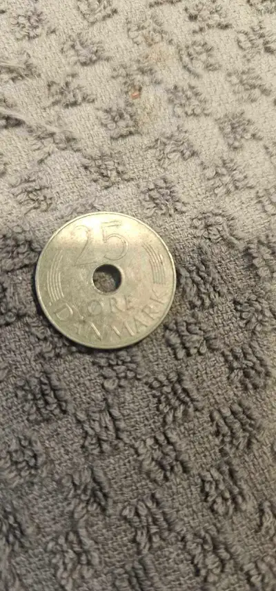 This 1974 Denmark 25 Ore coin features a distinctive centre-hole design and is in good condition, sh...