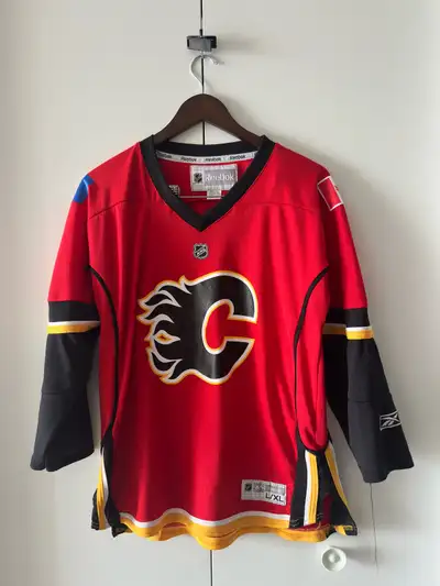 Show your team spirit with this Reebok Calgary Flames hockey jersey! This vibrant red jersey, in you...