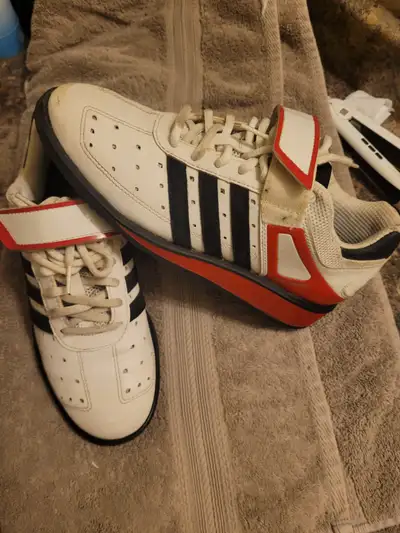 a pair of white and red adidas Power Perfect 2.0 weightlifting shoes, featuring a distinct hook-and-...