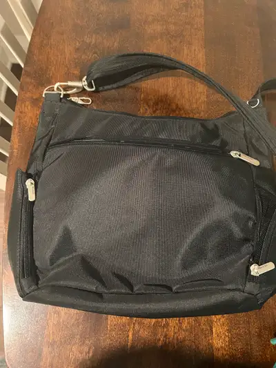 Anti-theft travel bag/purse. Lots of safety features, including zipper clips. Several pockets. A sma...